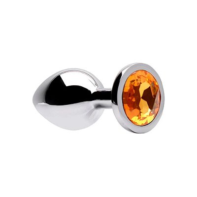 Plug anal de aço inoxidável tamanho M, acabamento cromado, formato redondo e detalhe de pedra dourada. Acompanha saco aveludado preto.